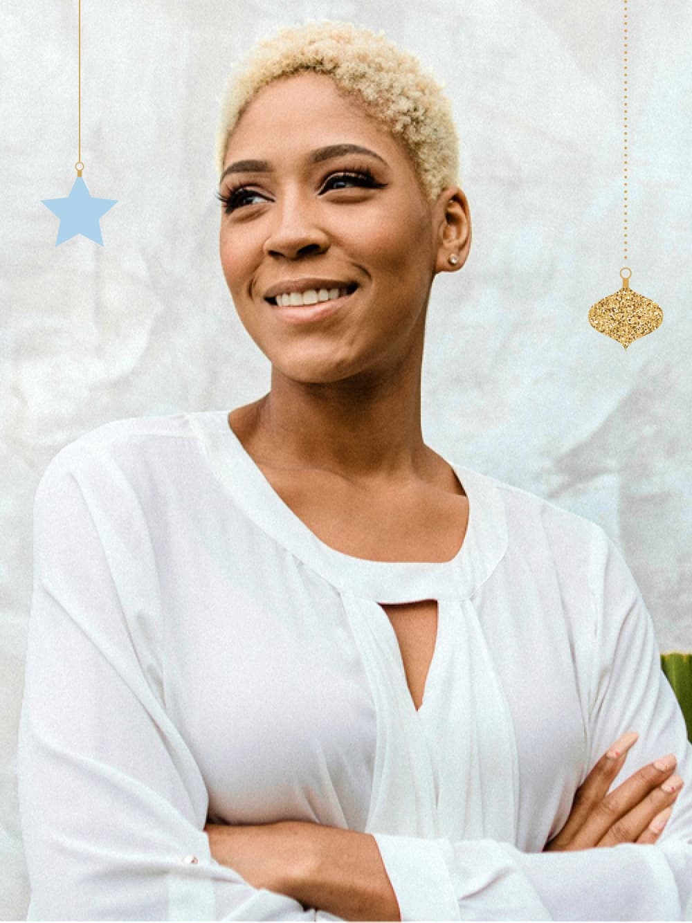 African-American woman with white blouse and short curly hair smiling.